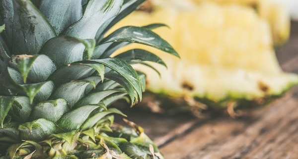 closeup of cut up pineapple on a wooden table