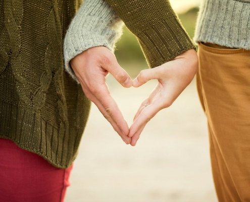 a couple making a heart with their hands