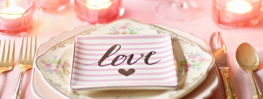 Table setting for Valentine's Day with a love napkin and pink candles