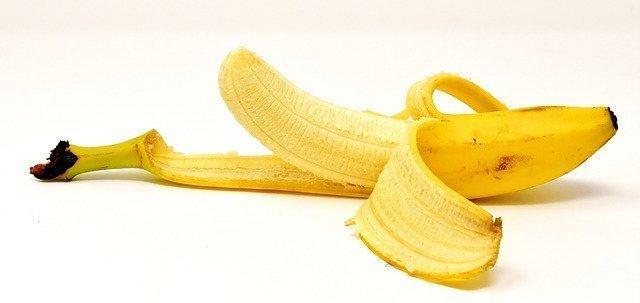 Is Banana an Aphrodisiac? The Benefits of Banana Sexually 1 half peeled banana laying on its side on a white background to illustrate banana aphrodisiac