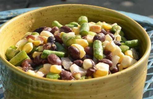 closeup of two bean salad in a yellow bowl