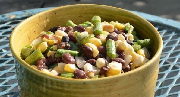 closeup of two bean salad in a yellow bowl