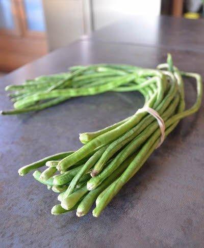 bunch of long beans on a gray counter