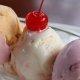 closeup of three scoops of ice cream, the middle one has a cherry on top