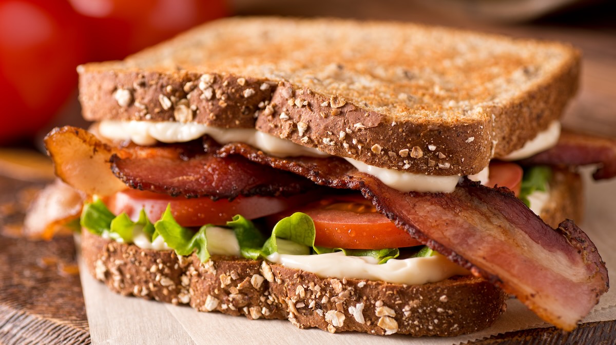 Closeup of a bacon, tomato and avocado picnic sandwich on whole grain bread