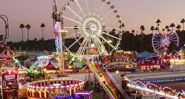 Sunset image of a romantic date at the LA County Fair ferris wheel and other ride attractions