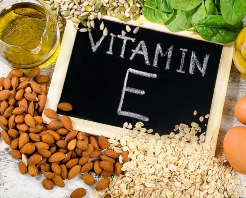Benefits of Vitamin E Sexually — The Real “Sex Vitamin” 2 chalkboard with "vitamin E" written in white chalk, surrounded by ingredients rich in vitamin E including almonds, wheat germ oil