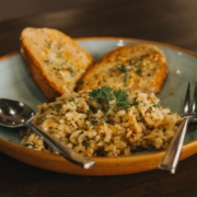 wild and brown rice pilaf in a clay bowl with a fork and spoon and toasted French bread