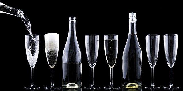 a line of champagne flutes on a black background to illustrate Best Champagnes