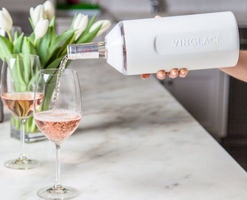 wine being poured from aVinglace wine cooler into a wine glass with tulips in the background