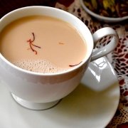 closeup of saffron tea in a white cup with a white saucer