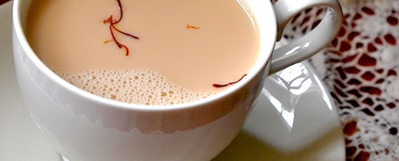 closeup of saffron tea in a white cup with a white saucer