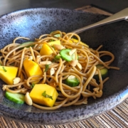 Soba Noodle Salad in a black bowl on a bamboo placemat