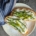 overhead shot of ricotta toast with asparagus on a cream colored plate with a blue napkin