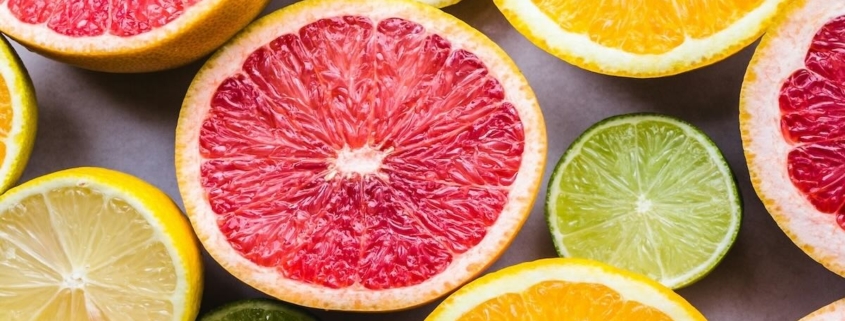a variety of cut citrus fruits in shades of pink, orange, yellow and green
