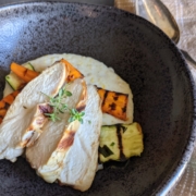 Easy Grilled Chicken Breast Recipe with Polenta and Vegetables 2 creamy polenta with grilled chicken and vegetables in a black bowl with a silver serving spoon and tan napkin