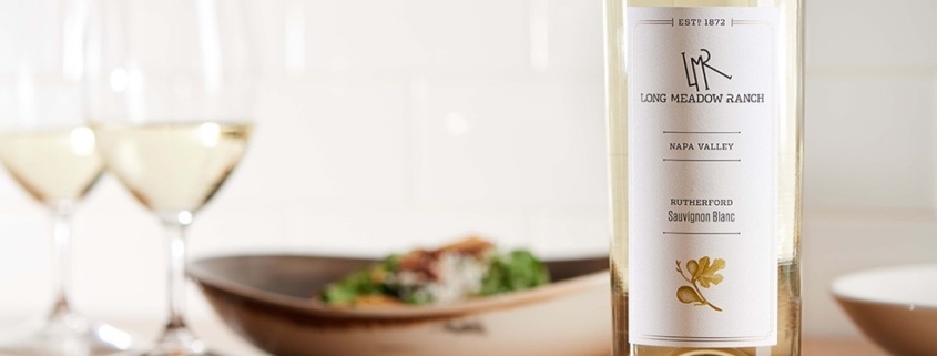 Long Meadow Ranch Sauvignon Blanc on a table with two glasses of wine