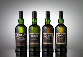 Four bottles of Scotch on a grey background