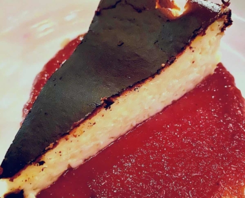 Basque Cheesecake Recipe 9 Burnt Basque Cheesecake with a red sauce on a white plate