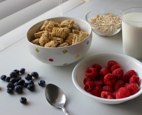 breakfast tray with berries and whole grains, glass of milk