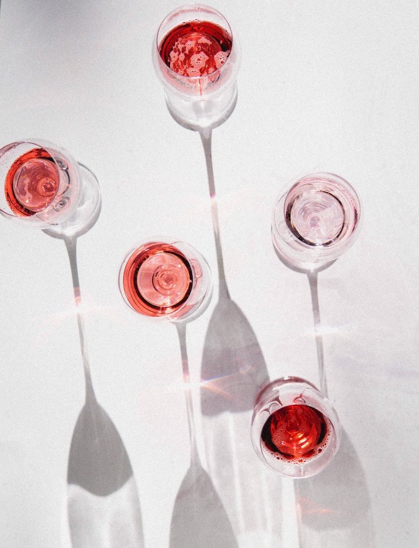 a wine tasting with glasses of rose wine on a white background