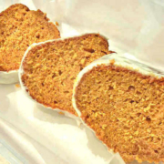 closeup of pumpkin bundt cake slices with cream cheese frosting on a white background