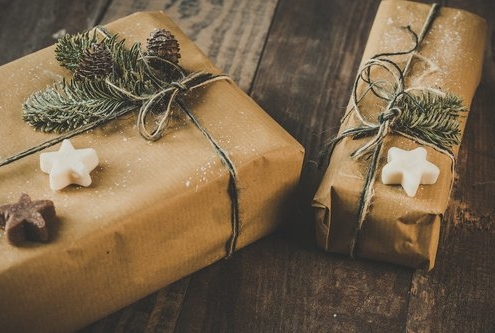 2 packages with brown paper wrapping, greenery and cookies to illustrate our 2020 gift guide