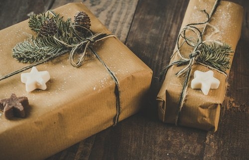 2 packages with brown paper wrapping, greenery and cookies to illustrate our 2020 gift guide