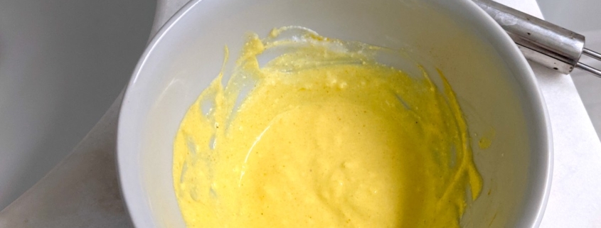 DIY yogurt and turmeric face mask in a white bowl with a whisk