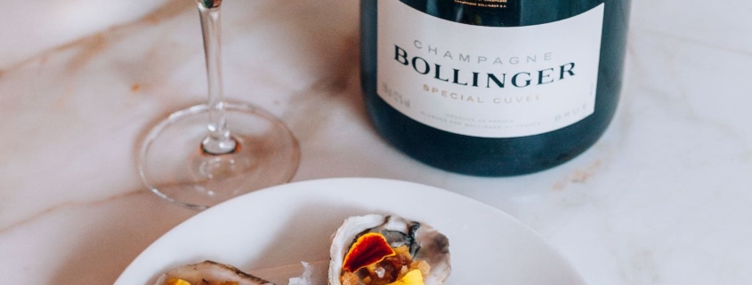 Bollinger Special Cuvee bottle on a white tablecloth with a plate of oysters