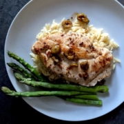 braised chicken breast with asparagus on a white plate