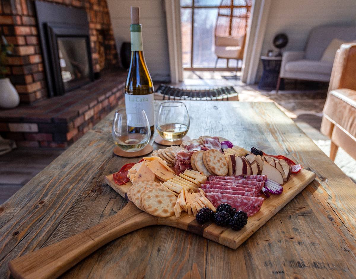 example of a charcuterie board to buy on a wooden table with a bottle of wine