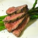 Marinated Grilled Bison with Asparagus on a White Plate