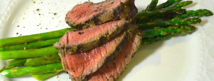 Marinated Grilled Bison with Asparagus on a White Plate