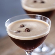 Tia Maria Espresso Martini Recipe 2 Closeup of a Tia Maria Espresso Martini with three espresso beans and a second drink in the background