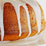 closeup of pumpkin bundt cake with a vanilla glaze on a white plate