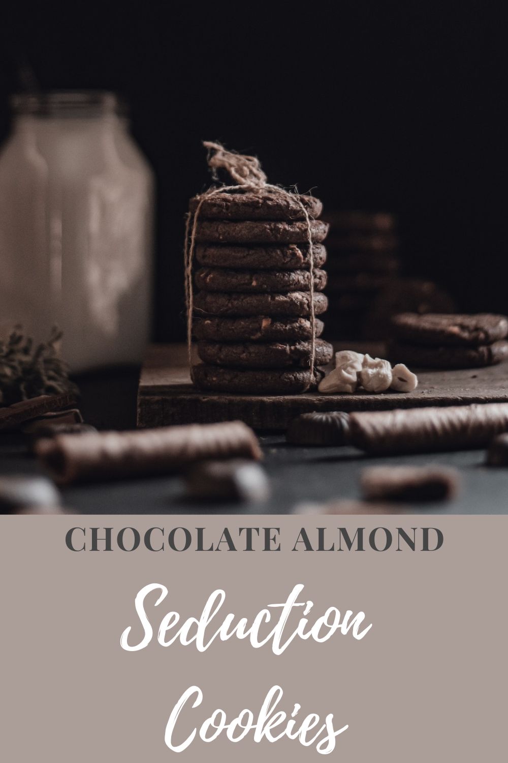 stack of chocolate almond cookies tied up with kitchen twine with assorted baking supplies in the background