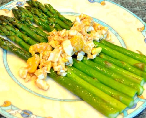 brown butter asparagus with eggs on a cream plate with blue trim