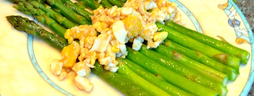 brown butter asparagus with eggs on a cream plate with blue trim