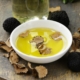 white bowl of oil with truffle pieces and truffles sitting beside the bowl