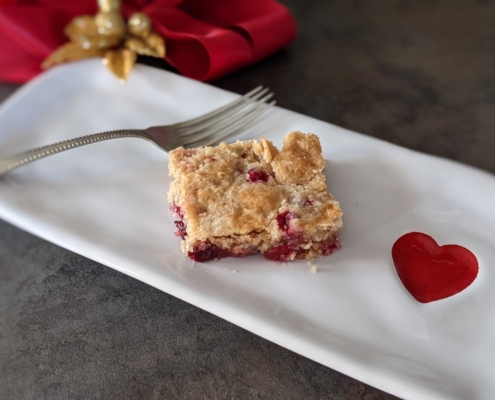 cranberry cake square on a rectangular plate with a red heart