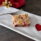 cranberry cake square on a rectangular plate with a red heart