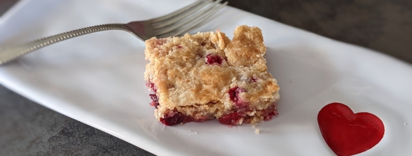 cranberry cake square on a rectangular plate with a red heart