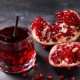 closeup of pomegranate mocktail with two straws and pieces of fresh pomegranate on the site