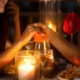 Couple holding hands at the dinner table lit by candlelight