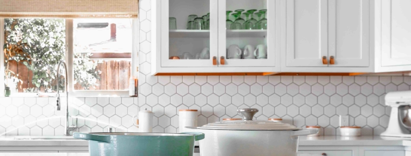 A white kitchen with various kitchen tools visible