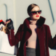 closeup of woman in winter coat holding numerous shopping bags