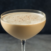 closeup of the chocolate cognac cocktail with a cocktail shaker in the background