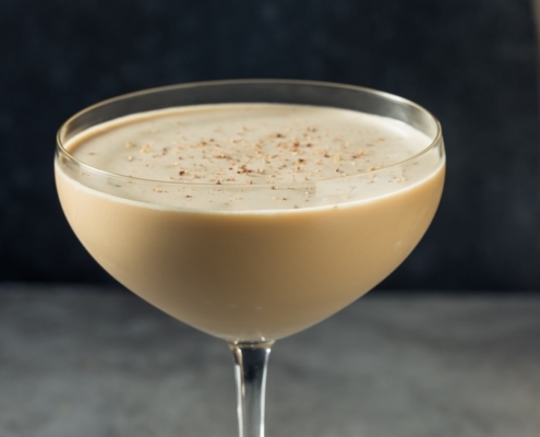 closeup of the chocolate cognac cocktail with a cocktail shaker in the background