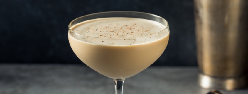 closeup of the chocolate cognac cocktail with a cocktail shaker in the background